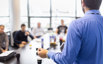 A man standing in front of his employees giving training 